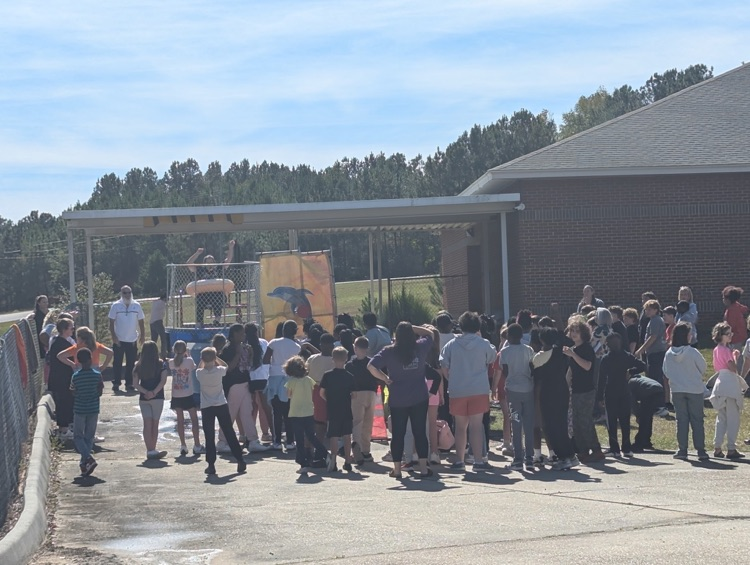 A group of students gathered around a dunking booth.