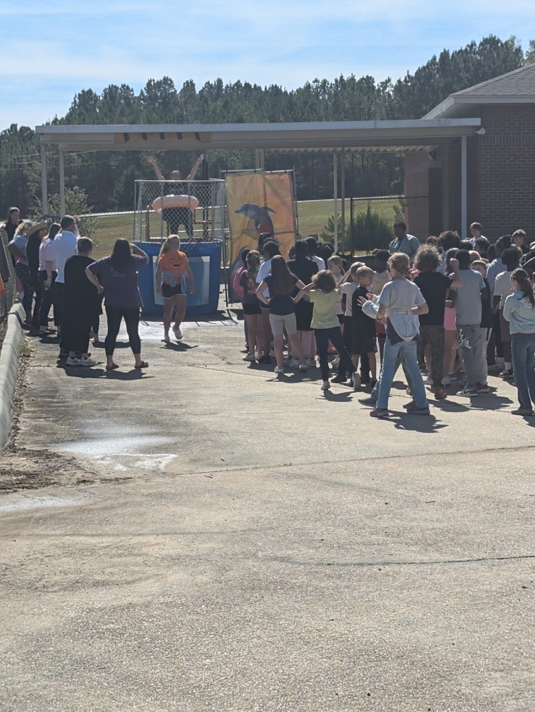 A group of students gathered around a dunking booth.