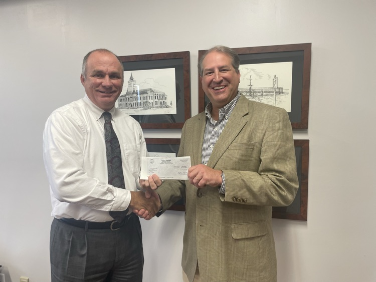 Two men holding a check against a white background .