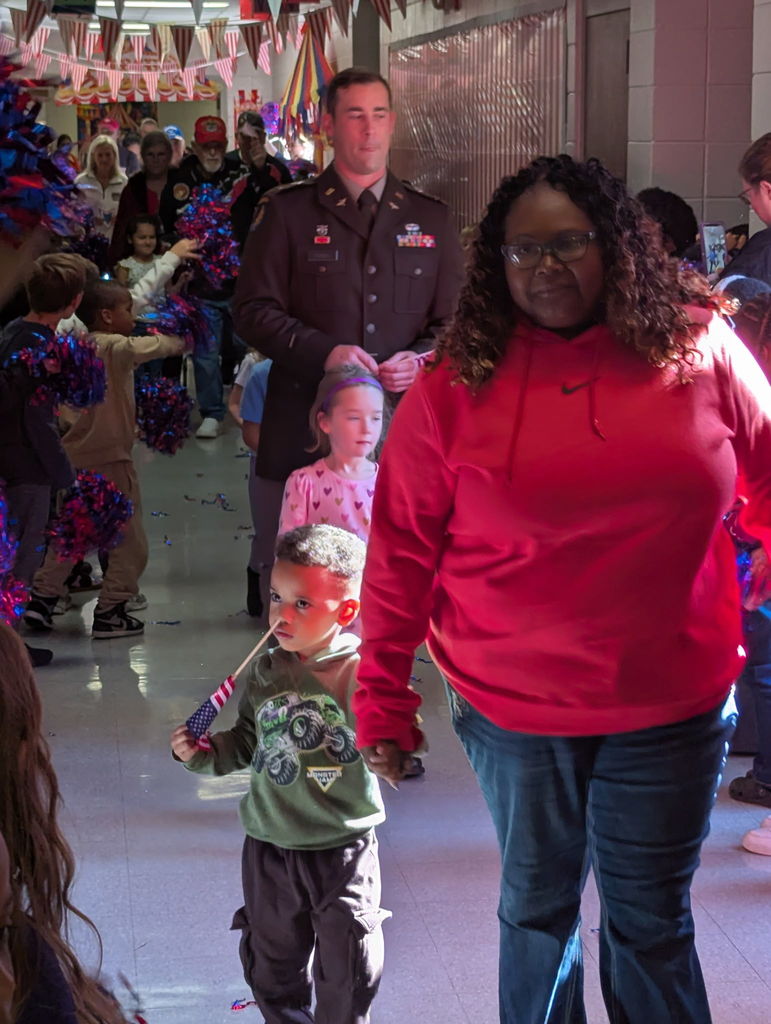 A group of people walking down a hallway.