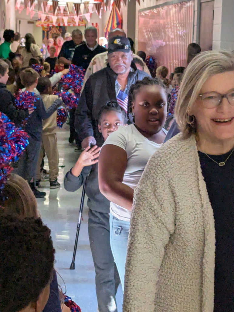 A group of people walking down a hallway.