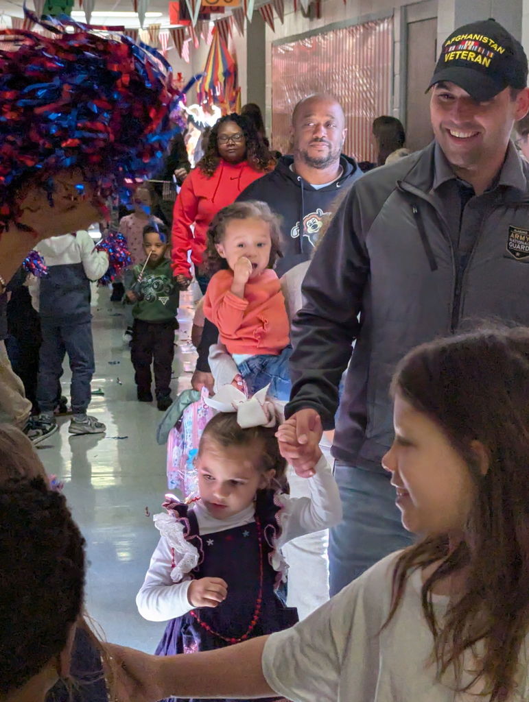 A group of people walking down a hallway.