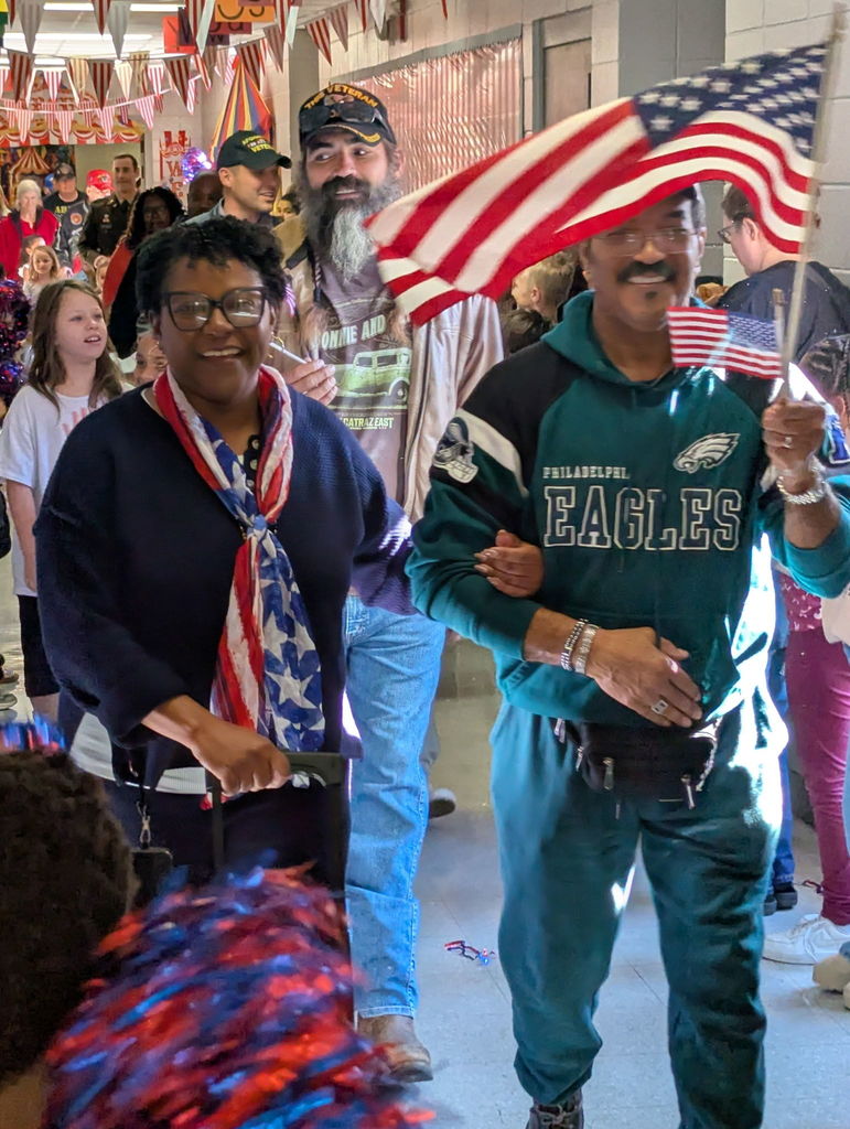 A group of people walking down a hallway.