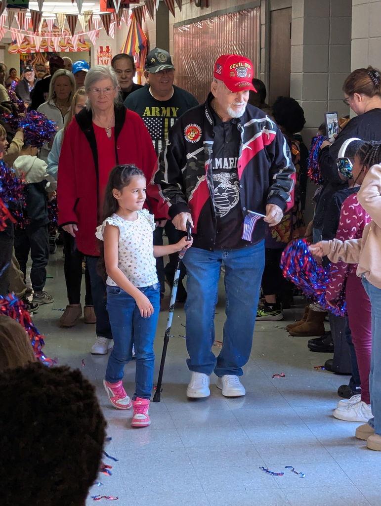 A group of people walking down a hallway.