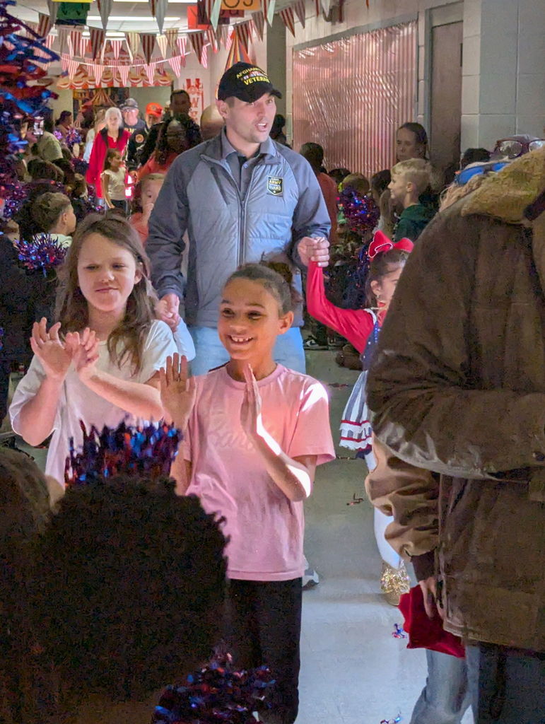 A group of people walking down a hallway.