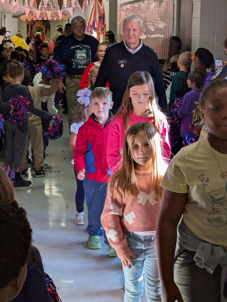 A group of people walking down a hallway.