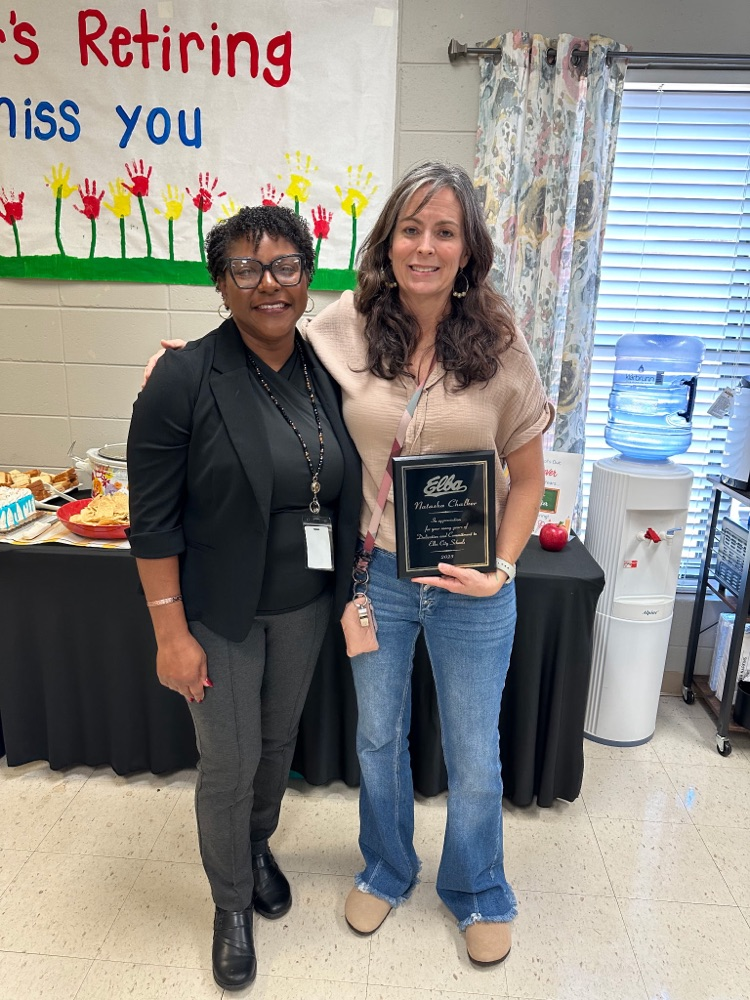 Two women standing in front of the table