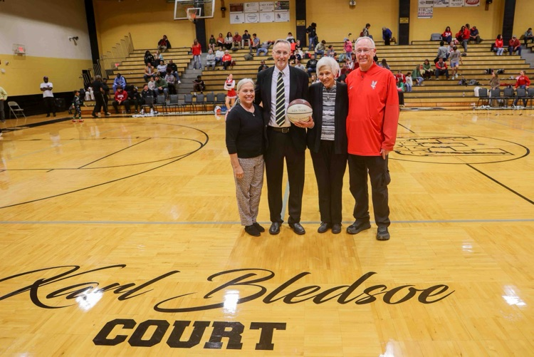 A group of people standing on a basketball court.