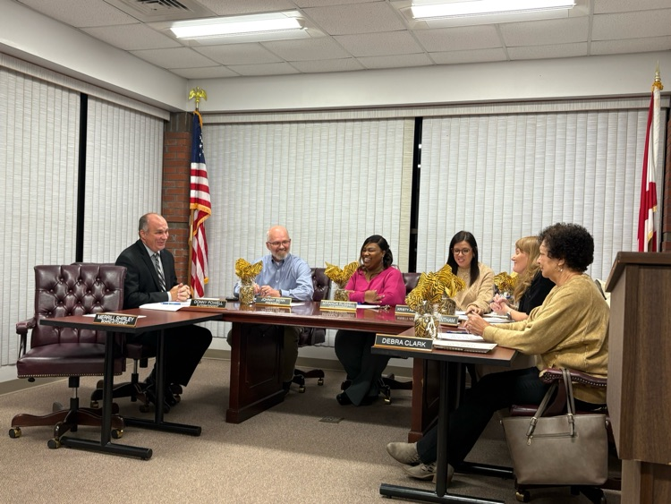 A group of people sitting at a board table.