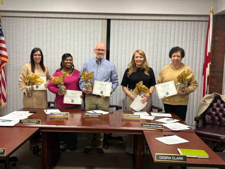 A group of people sitting at a board table.