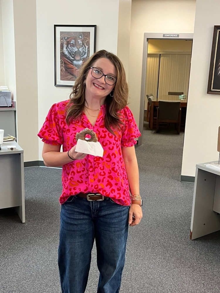 A lady holding a donut.