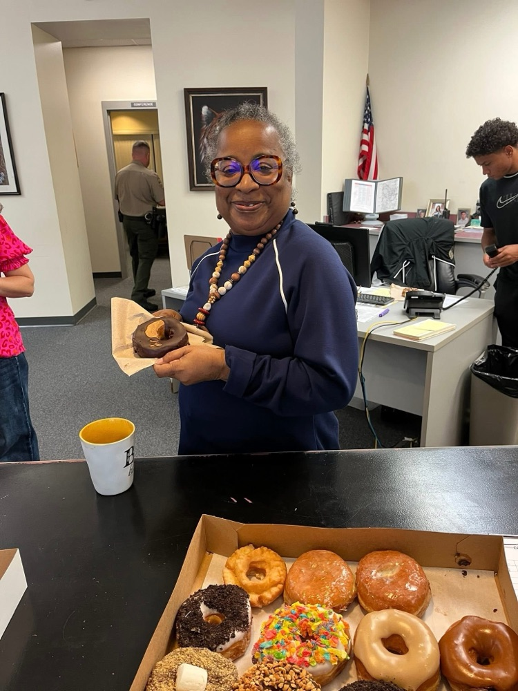 A lady holding a donut.