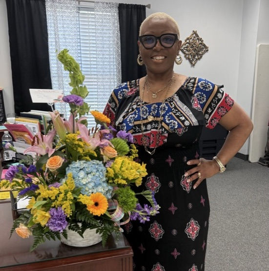 A woman standing in front of a desk.