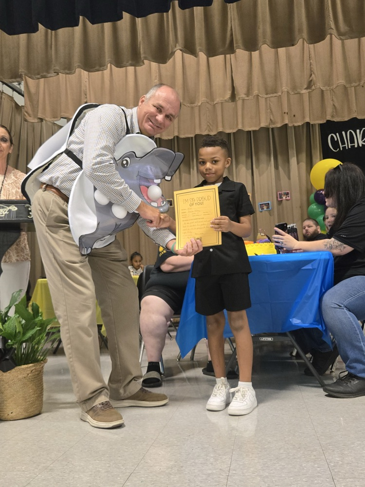 A man presenting a student with an award.