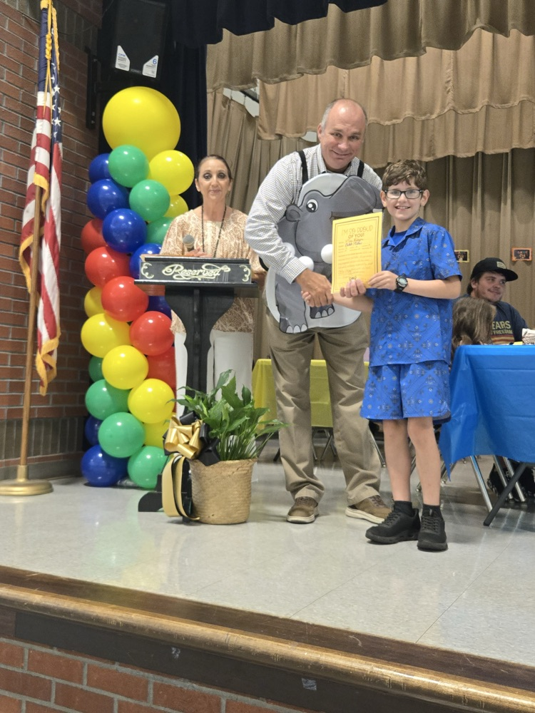 A man presenting a student with an award.
