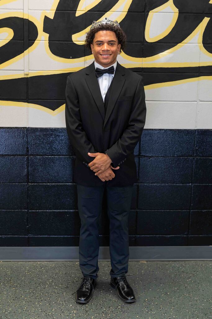 A male student standing by a wall.