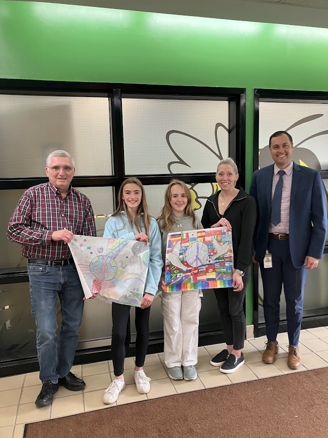 Image of students holding the poster submission they entered into a contest.