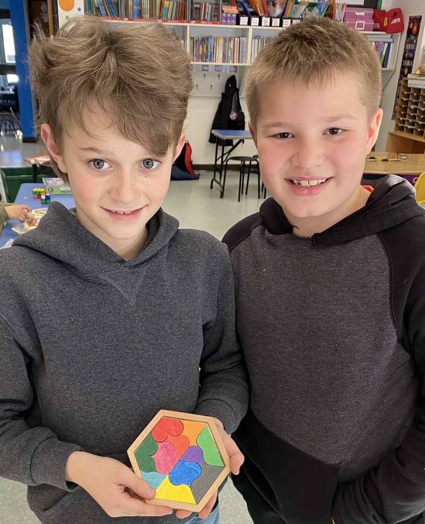 Image of two student showing off the wooden puzzle they just completed