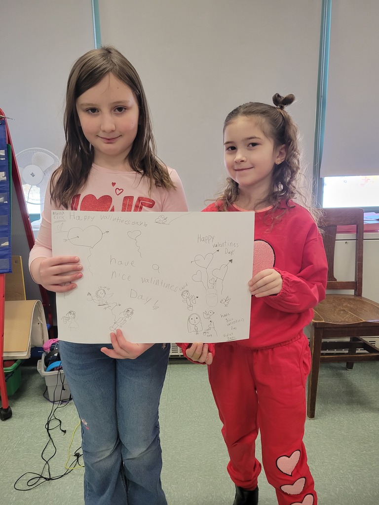 Image of students holding up the Partner drawing they made in friendship club