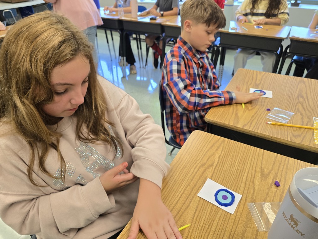 students in 6th grade science class making a model of an animal cell out of playdoh