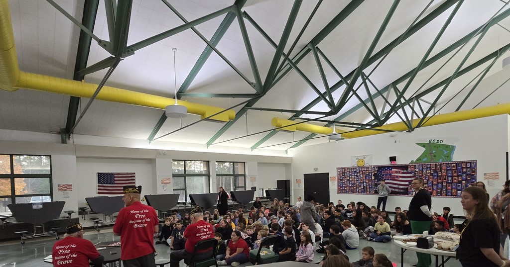 Image of students sitting on the floor during a Q & A session with local veterans