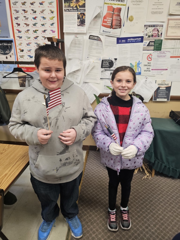 Two students are posing for the camera with hand-held American Flags