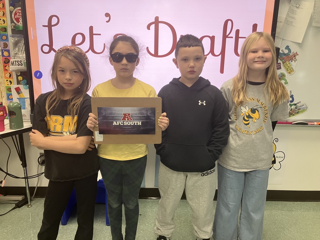 Image of students on "draft day" for their NFL fantasy football reading challenge posing with their team