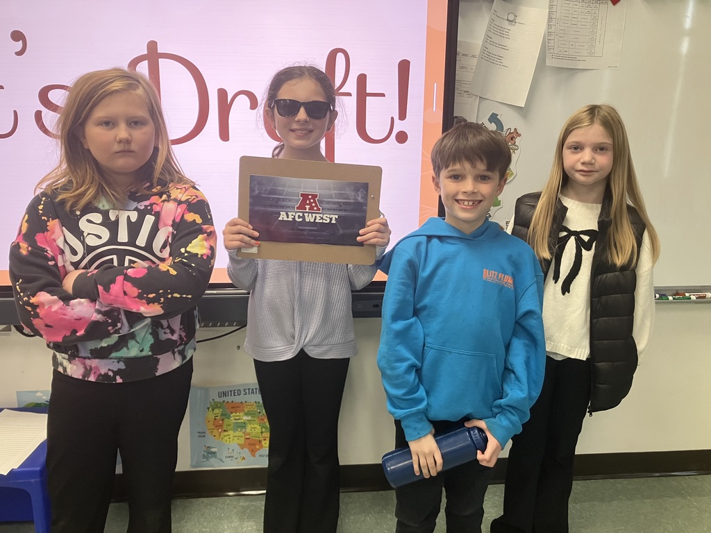 Image of students on "draft day" for their NFL fantasy football reading challenge posing with their team