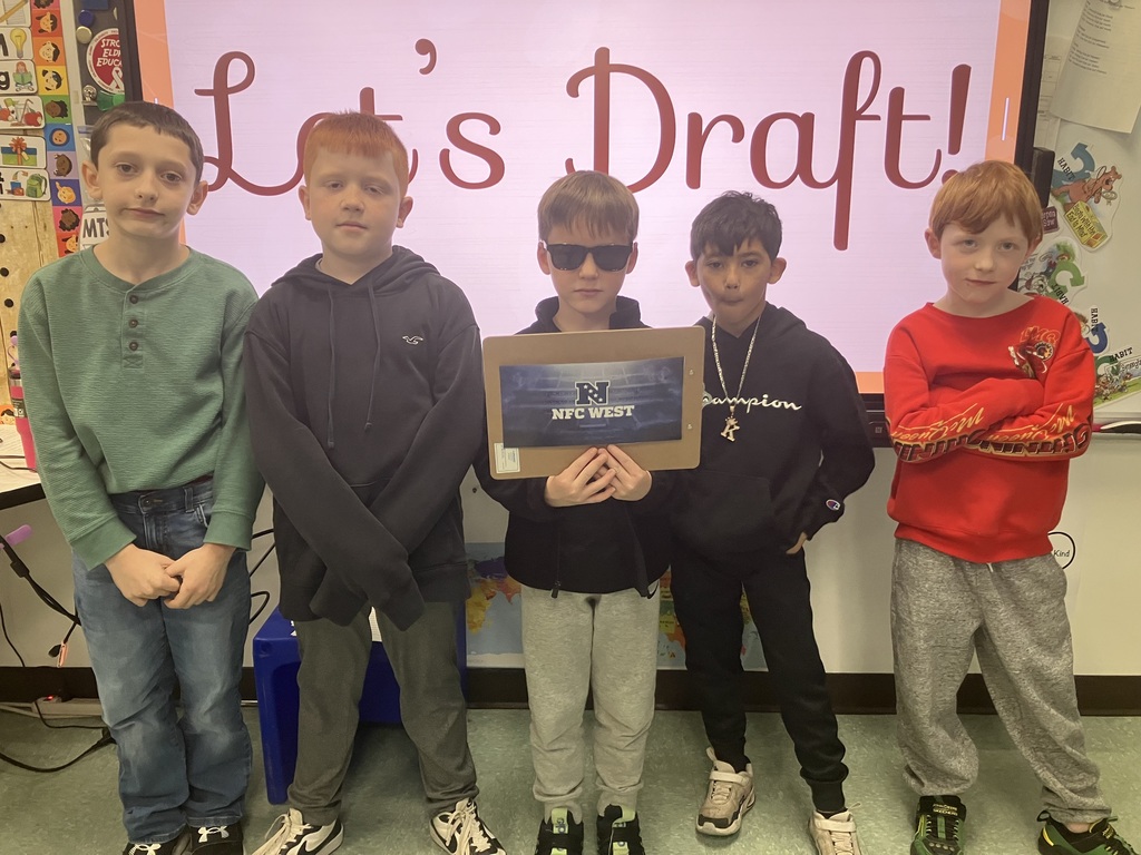 Image of students on "draft day" for their NFL fantasy football reading challenge posing with their team