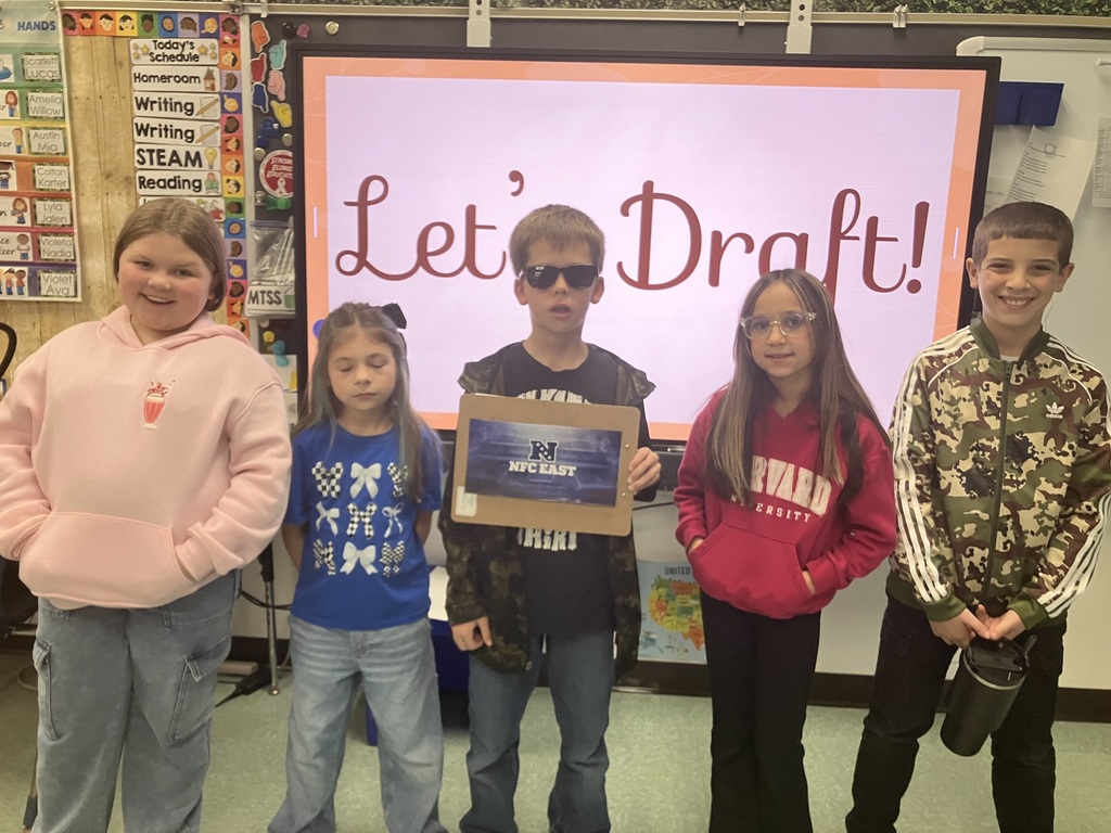 Image of students on "draft day" for their NFL fantasy football reading challenge posing with their team