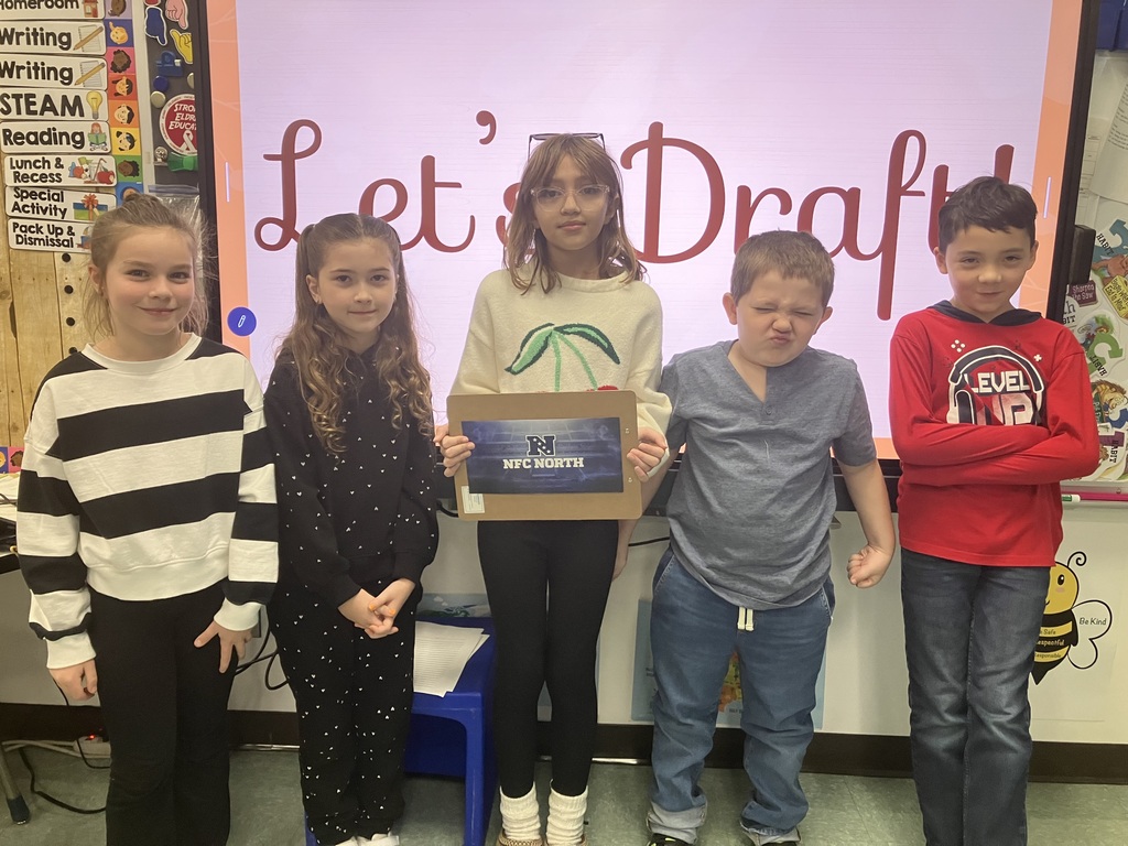 Image of students on "draft day" for their NFL fantasy football reading challenge posing with their team