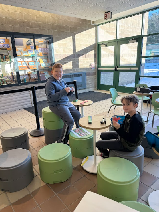 Image of students working on pieces which will hang on a bulletin board