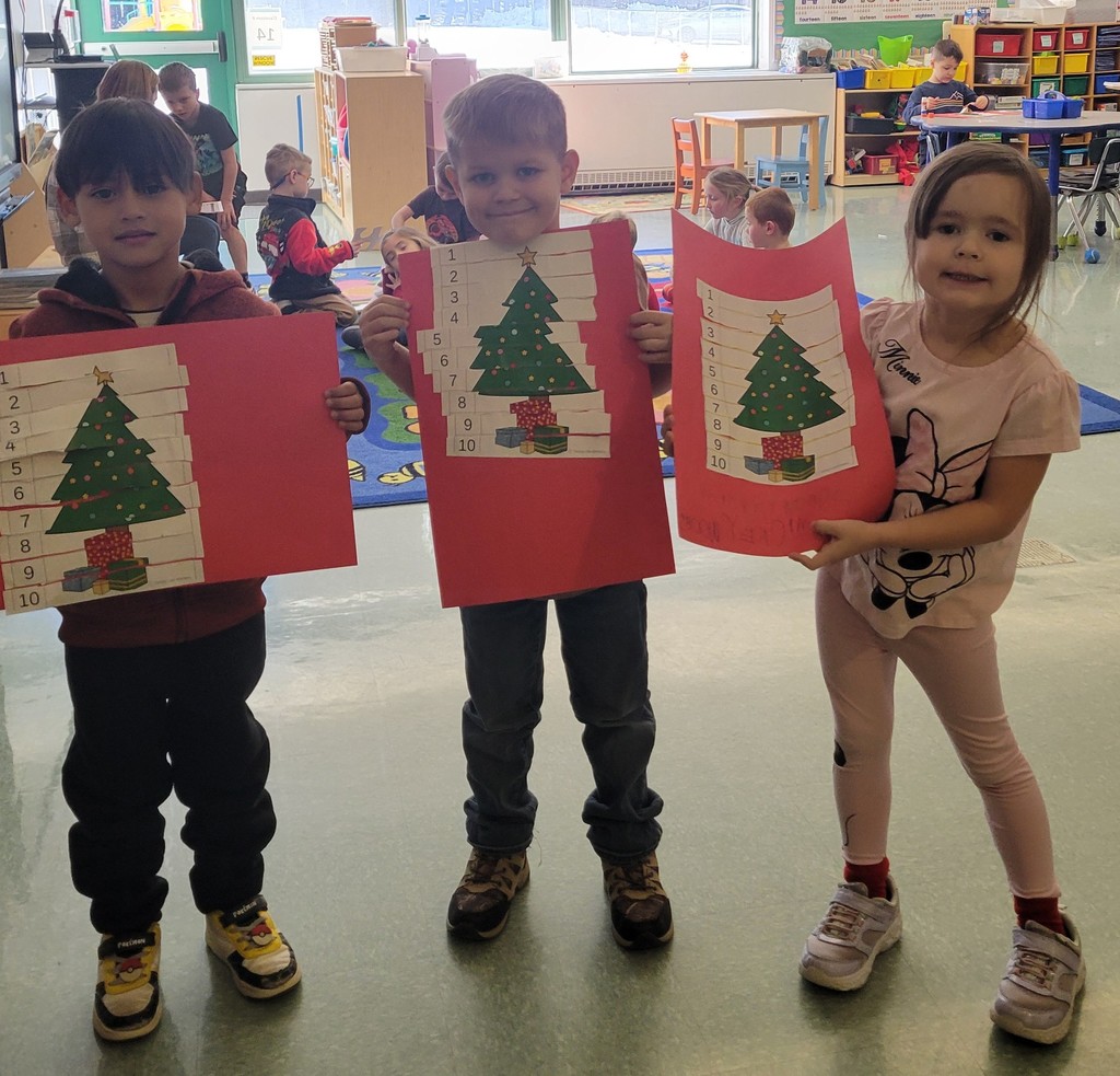 Students hold up their sequencing Christmas Tree project