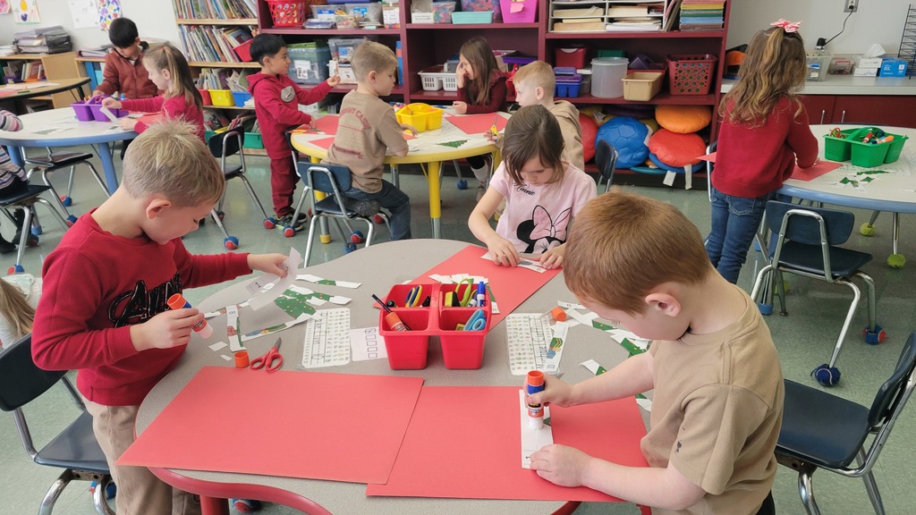 Students in kindergarten work on a sequencing project at their table