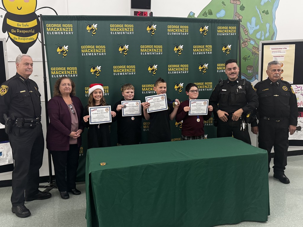 Image of the 4 DARE essay & poster contest winners with their certificates and standing with local dignitaries 