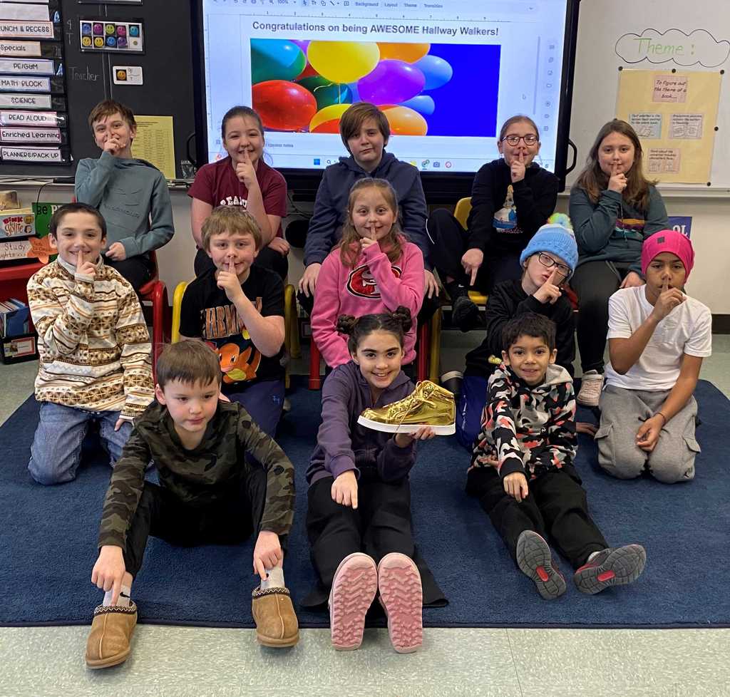 Image of a class holding up their Golden Shoe award for being recognized as good examples in the hallways