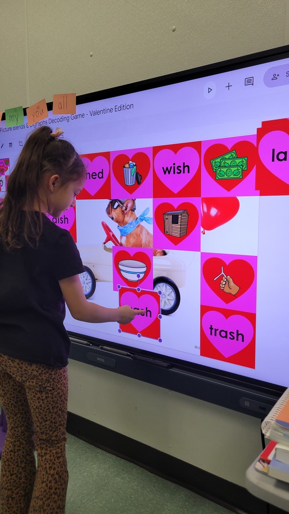 A student plays a winter themed literacy game at a smartboard