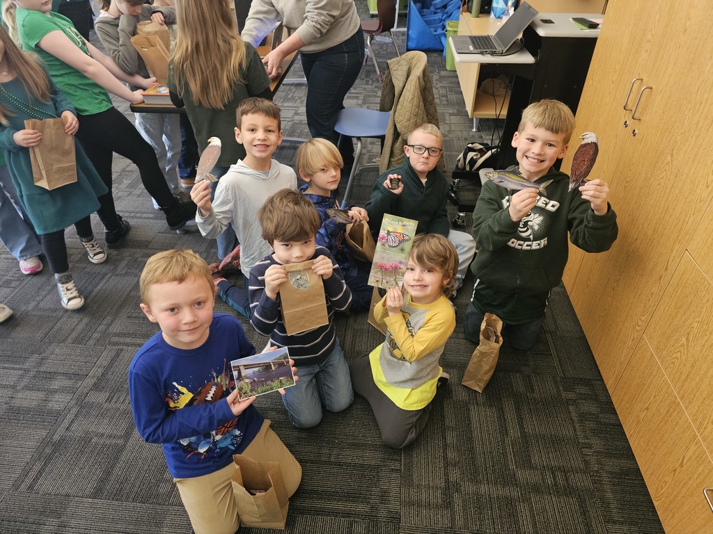 a group of children show off items they got from representatives from the National Park Service