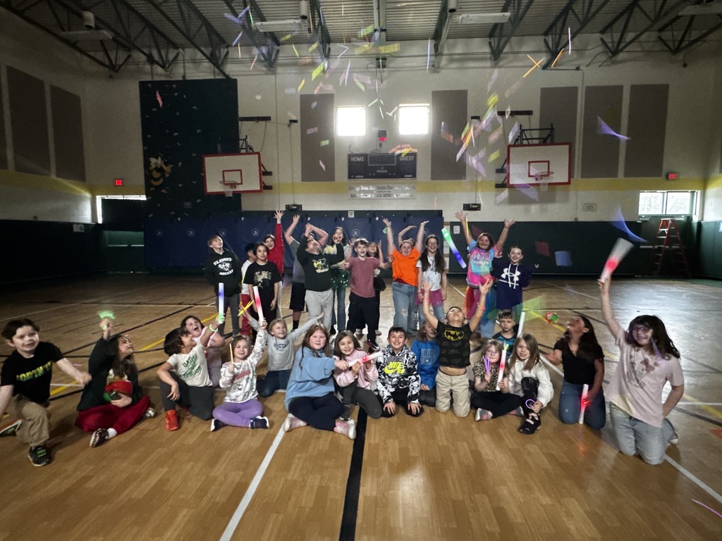 Students pose for a photo  and throw glow sticks in air