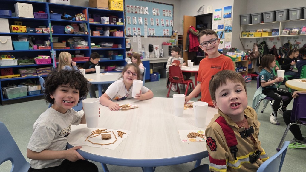 Image of students enjoying snacks in the classroom during their hot chocolate party that they earned for positive behavior choices.