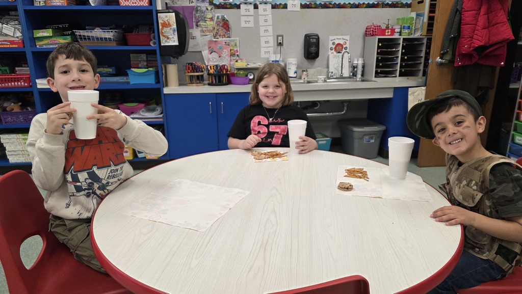 Image of students enjoying snacks in the classroom during their hot chocolate party that they earned for positive behavior choices.