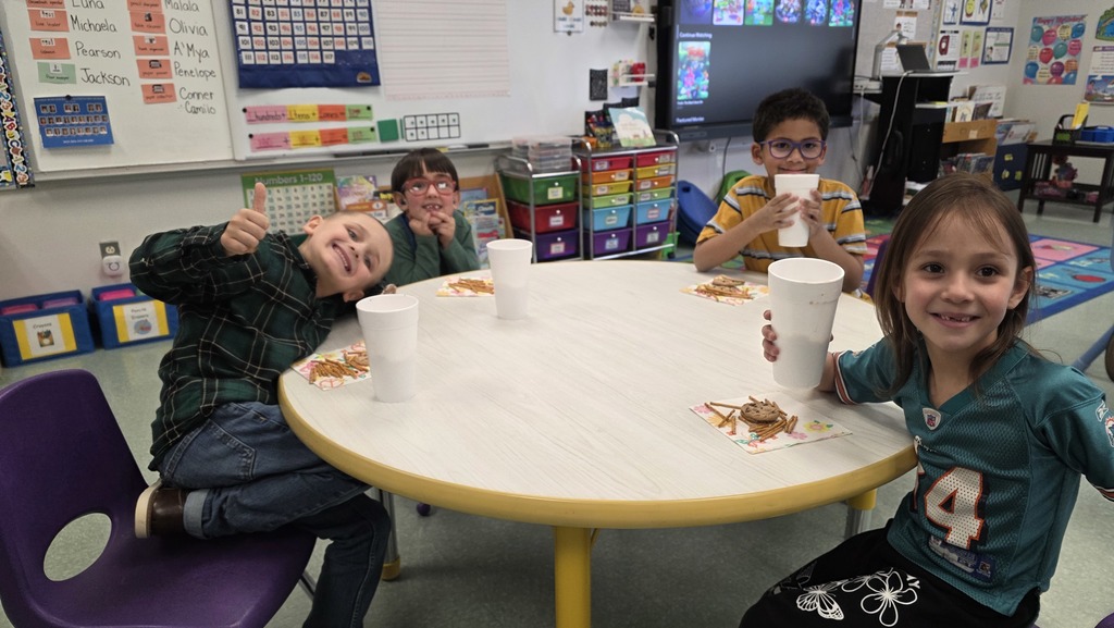 Image of students enjoying snacks in the classroom during their hot chocolate party that they earned for positive behavior choices.