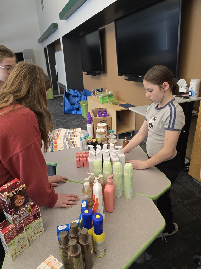 Image of students setting up health & beauty items for our community food pantry