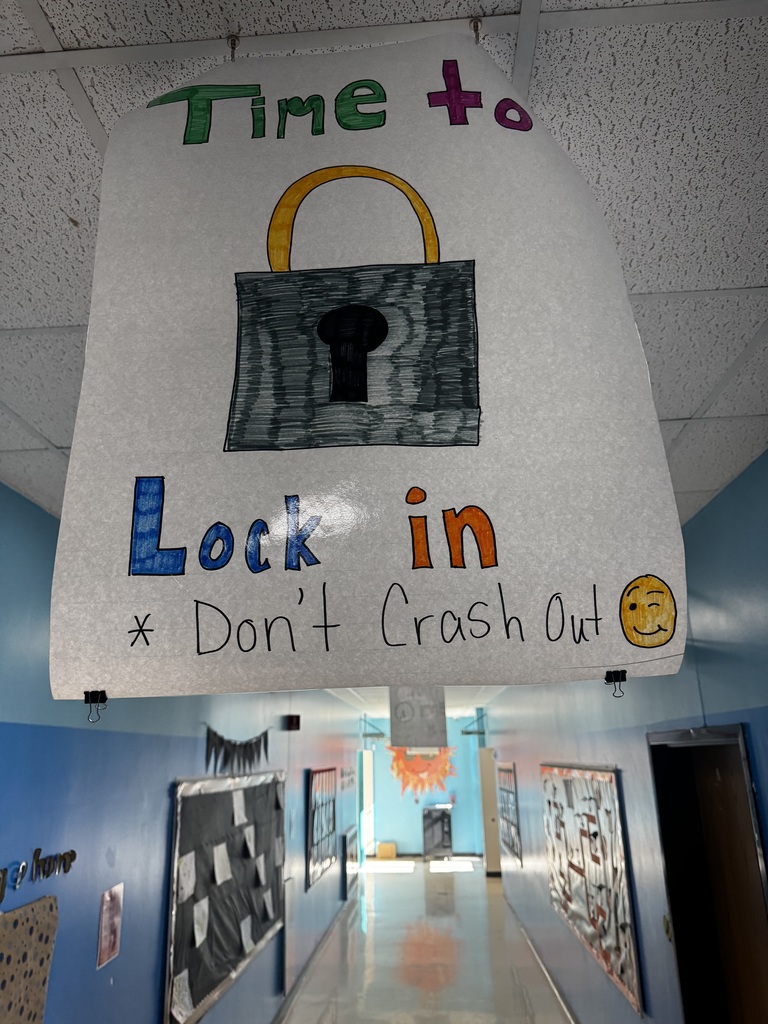 Image of a poster hanging from the ceiling of a school hallway that reads "Time to Lock in Don't Crash Out"