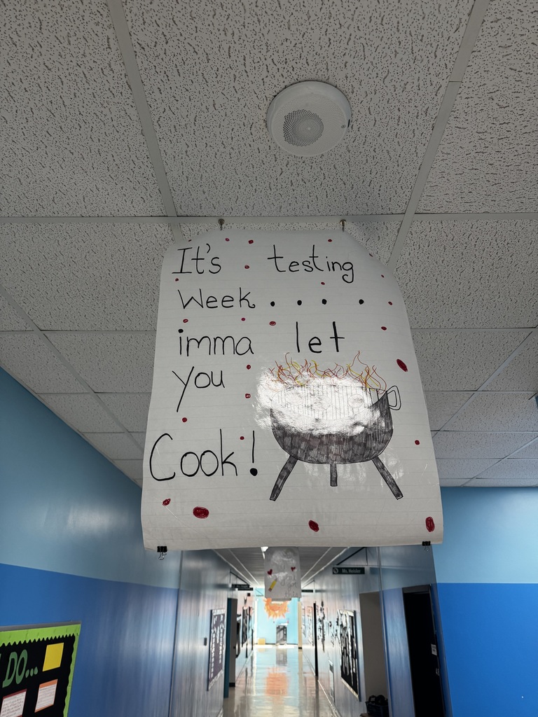 Image of a poster hanging from the ceiling of a school hallway that reads "It's Testing Week...Imma let you cook!"