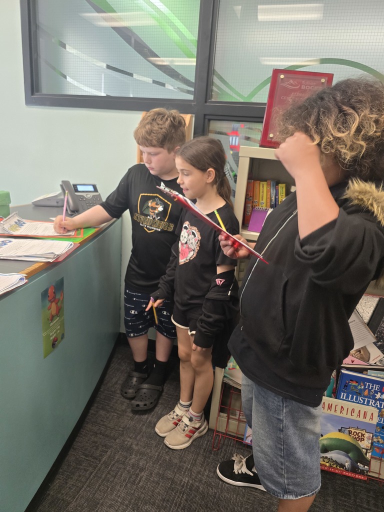 Image of students in a school office looking for Pokemon for a math assignment