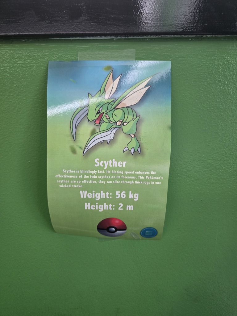 Image of the Pokemon, Scyther, posted on a green wall 