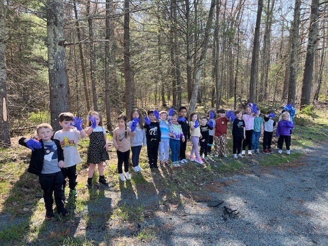 Image of student participating in a litter pluck for Earth Day on school grounds