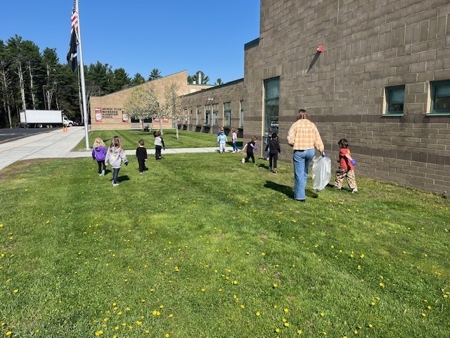 Image of student participating in a litter pluck for Earth Day on school grounds