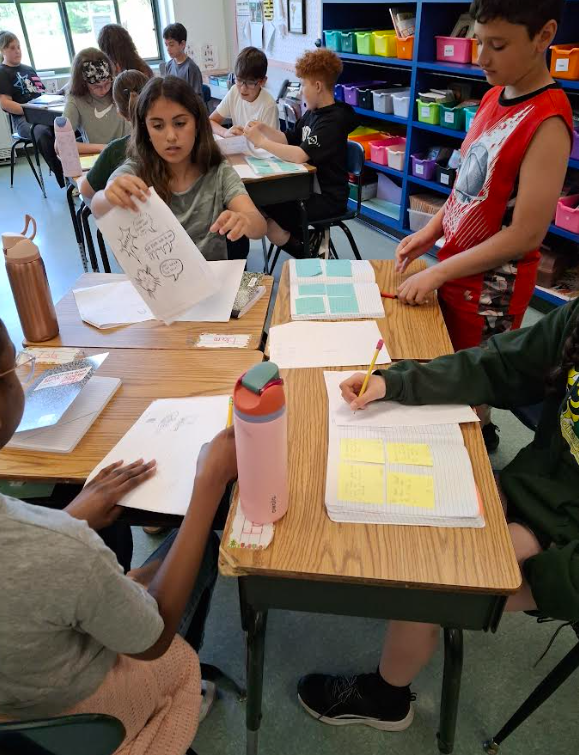 Image of students at their desks working on a writing assignment